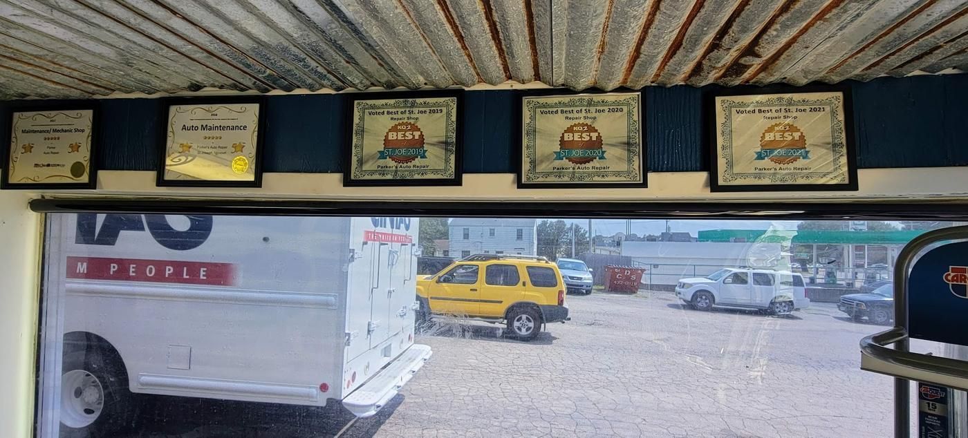 A row of five framed award plaques above the office window at Parker's Auto Repair